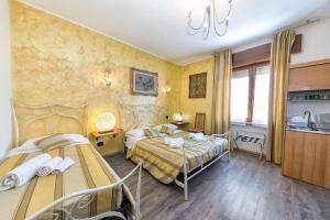 Habitación de hotel con 2 camas y cocina en Residenza le dimore 3, en Verona