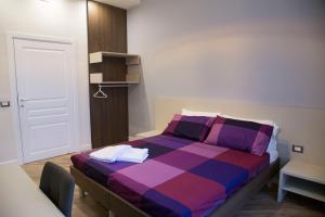 a bedroom with a bed with purple and purple at Garibaldi Rooms in Naples