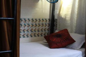 a red pillow sitting on top of a bed at First IN in Madgaon