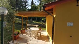 d'une terrasse avec une table et des chaises sous une pergola. dans l'établissement Casina Margherita, à Sienne