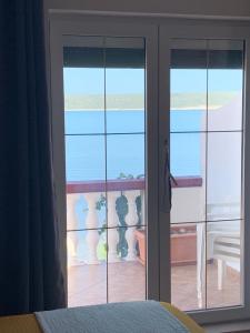 uma porta de vidro com vista para uma varanda em Villa M Studio Apartment em Ljubac