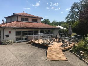 une terrasse avec des tables, des chaises et un parasol dans l'établissement Hôtel Restaurant L'Artière, à Ceyrat