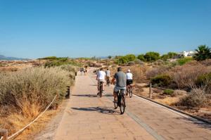 a group of people riding bikes down a path at Mallorca Rooms Can Pastilla in Can Pastilla