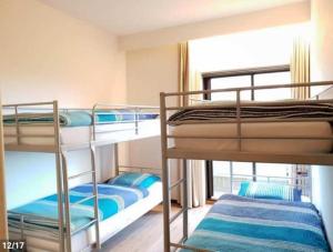 3 stapelbedden in een kamer met een raam bij Residentie Noordhinder - Hendrik Consciencelaan 8 - appartement G 0 08 - 8660 De Panne - België in De Panne