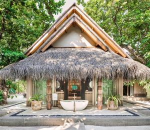 a small hut with a tub in front of it at JOALI Maldives in Raa Atoll