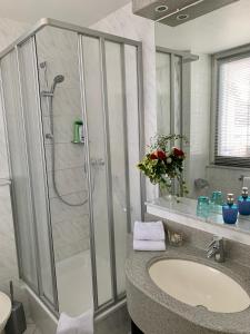 La salle de bains est pourvue d'une douche et d'un lavabo. dans l'établissement Art Hotel Köln, à Cologne