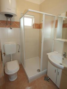 a bathroom with a shower and a toilet and a sink at Apartments Novalja in Novalja
