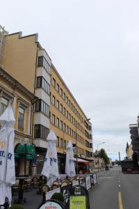 un grupo de mesas con sombrillas blancas en una calle de la ciudad en Apartment Widbominkulma en Pori