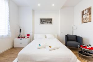 - une chambre blanche avec un lit et une chaise dans l'établissement MISIRLOU -Superbe Studio dans la Vieille Ville, à Marseille
