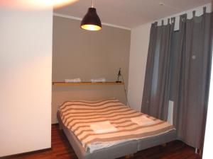 a small bedroom with a bed with a striped blanket at North Inn B&B in Sollefteå