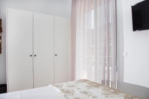 a bedroom with a bed and a window with curtains at Elenis Philoxenia in Ixia