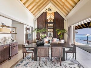 an open kitchen and dining room with a table and chairs at JOALI Maldives in Raa Atoll