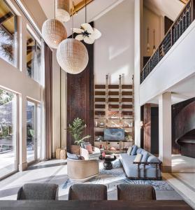 a living room with a couch and chairs and a fireplace at JOALI Maldives in Raa Atoll