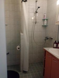 baño con ducha con cortina blanca en Apartment Widbominkulma en Pori