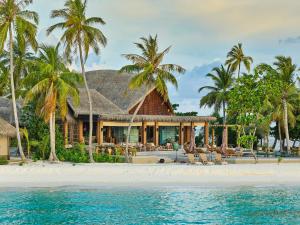 a house on a beach with palm trees at JOALI Maldives in Raa Atoll