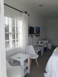 a bedroom with white furniture and a bed and a window at Franmarel in Plettenberg Bay