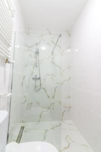 een witte badkamer met een douche en een toilet bij CANDY ROOM in Olsztyn