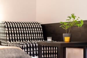 un salon avec un canapé et une table avec une plante dans l'établissement Apartments Wilcza 55 by Renters, à Varsovie