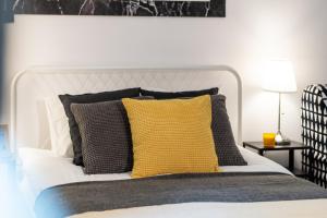 sypialnia z białym łóżkiem i żółtą poduszką w obiekcie Apartments Wilcza 55 by Noclegi Renters w Warszawie