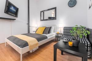 sypialnia z łóżkiem, stołem i kanapą w obiekcie Apartments Wilcza 55 by Noclegi Renters w Warszawie