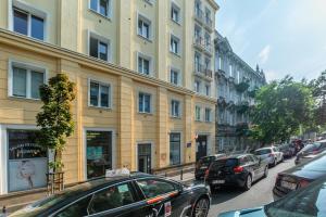 ruchliwa ulica miejska z samochodami zaparkowanymi przed budynkami w obiekcie Apartments Wilcza 55 by Noclegi Renters w Warszawie +6 zdjęć