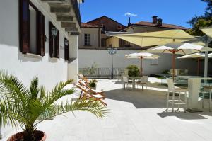 a patio with tables and chairs and umbrellas at Boutique Hotel La Rinascente in Locarno