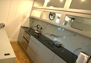 une cuisine avec un comptoir et une horloge au mur dans l'établissement Blue Velvet Premium Apartments, à Toruń 19 autres photos