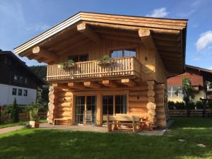 a log cabin with a deck and a table at Chalet Karin in Hochfilzen
