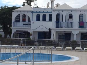 a white house with a swimming pool in front of it at ETNICAN in San Bartolomé de Tirajana