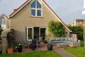 a house with a couch and a table in the yard at Hello Zeeland - Vakantiehuis Zwin 092 in Breskens