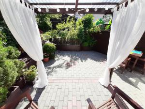 a patio with a white pergola and some plants at Słonecznik Jastarnia. Domek na Zdrojowej. in Jastarnia