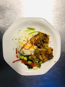 un piatto di alimenti con riso, pollo e verdure di Vahlavi Lodge a Giyani
