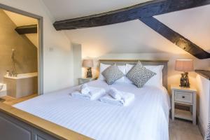 um quarto com uma cama branca e 2 candeeiros em The Hopton Crown em Cleobury Mortimer