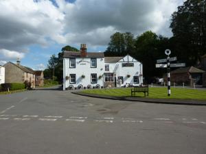 een wit gebouw aan de straatkant bij The Blacksmiths Arms in Brampton