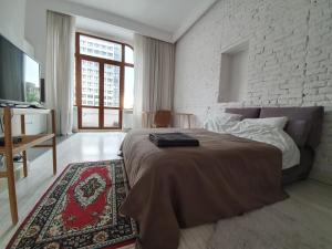 - une chambre avec un lit et un mur en briques dans l'établissement Prawdopodobnie najlepsze miejsce przy OFF Piotrkowska, à Łódź