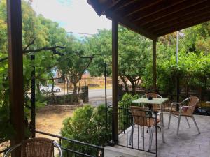 patio con tavolo e sedie sotto il portico di Paradisos Studios a Pyrgi Thermis