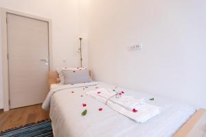 a white bed with flowers on it in a room at Your ONE and ONLY in Belgrade
