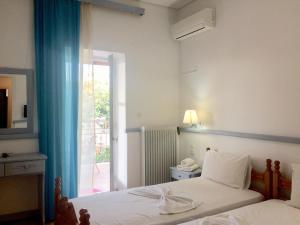 a bedroom with a bed and a door to a balcony at Paradisos Studios in Pyrgi Thermis +166 photos