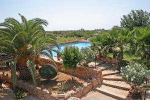 un complejo con piscina y palmeras en Finca Son Guardiola, en Llucmajor