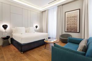 um quarto de hotel com uma cama e um sofá em One Shot Recoletos 04 em Madrid