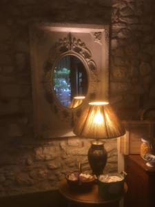 une lampe assise sur une table devant un miroir dans l'établissement B&b Corte Giare, à SantʼAmbrogio di Valpolicella
