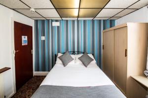 a bedroom with a large bed with blue walls at MyRoomz Silver Strand Hotel in Blackpool
