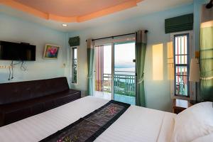 a bedroom with a bed and a couch and a balcony at Hotel Viewpoint Khao Koh in Khao Kho