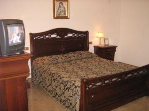 布塞托帕利佐洛Villa Violetta的一间卧室配有一张床和电视