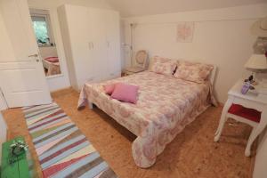 a bedroom with a bed with a pink pillow on it at Apartment Čamo in Sarajevo