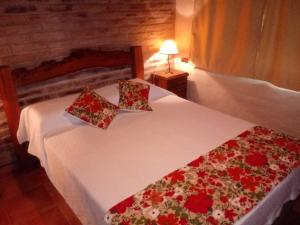 Giường trong phòng chung tại Cabañas El Refugio del Atuel
