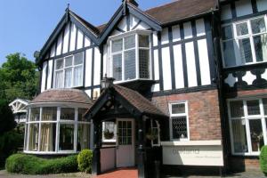 The oaklands hotel في Weaverham: منزل أبيض وأسود مع شرفة