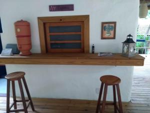 un mostrador con dos taburetes y una mesa en Mandacaru Guest House en Praia do Forte