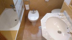 a bathroom with a sink and a toilet and a tub at Hotel Paloma in San Pedro del Pinatar