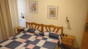 a bedroom with a bed with a blue and white quilt at Hotel Paloma in San Pedro del Pinatar